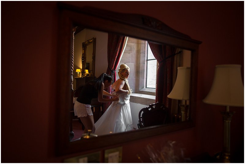 Bride getting into wedding Dress | Peckforton Castle Wedding Photography Karli Harrison Photographer