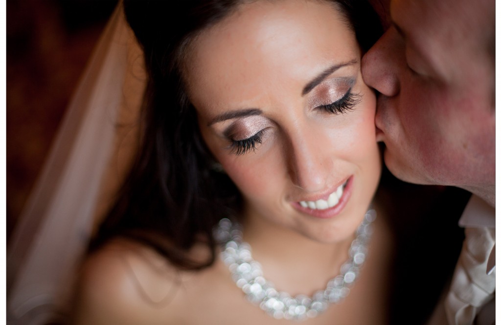 Close up of groom tenderly kissing his bride on the cheek at West Tower. Lancashire Wedding Photography
