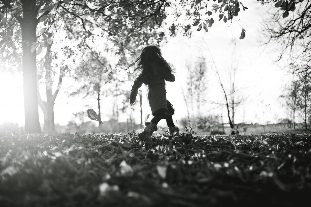 A girl running through autumn leaves in Ashton Park, Preston. Lifestyle Family Portraits
