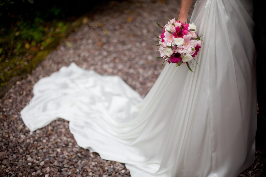 A creative shot of a bride and her flowers, and her dress from the waist down
