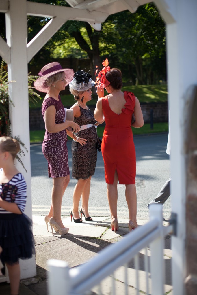 Three lady guests await the arrival of the bride