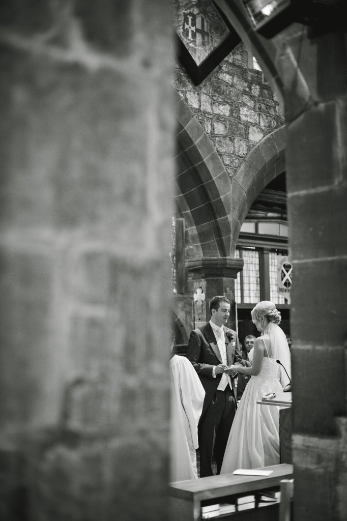 Peering through the columns of the church, photojournalism wedding photography