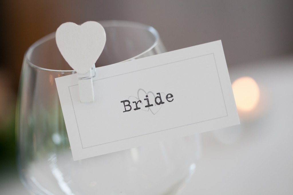 Bride place card hanging from her wine glass. Detailed wedding photography