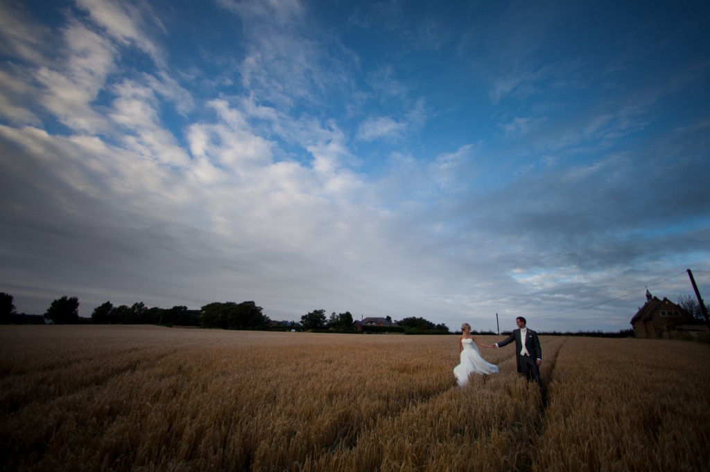 Walking through a field for their wedding photography, Lancashire
