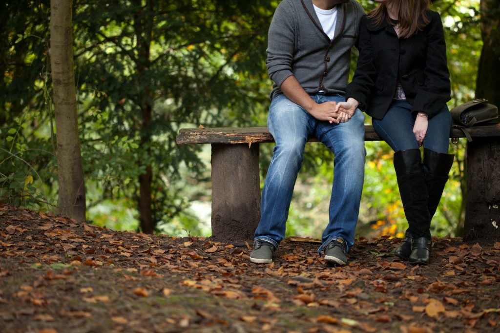 Couple sitting hand in hand in a forest, pre wedding shoot Lancashire
