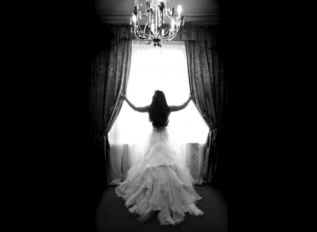 A beautiful Bride stands in the window of Northop Hall, beautiful and creative wedding photography Wales and beyond