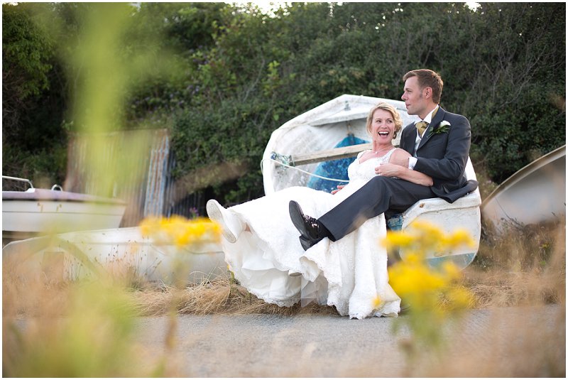 Bride and groom in a boat at Wales wedding