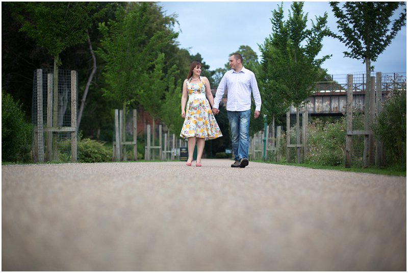 A couple walking during engagement shoot, holding hands