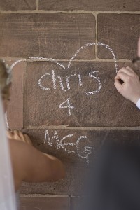 Love heart - a couple write their names on a wall in chalk