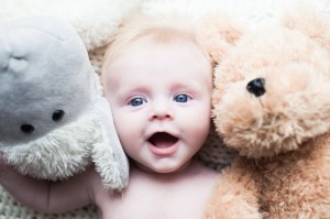 A baby smiling with her teddies Wirral