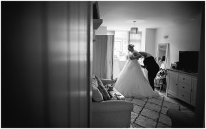 Bride getting in dress on wedding morning